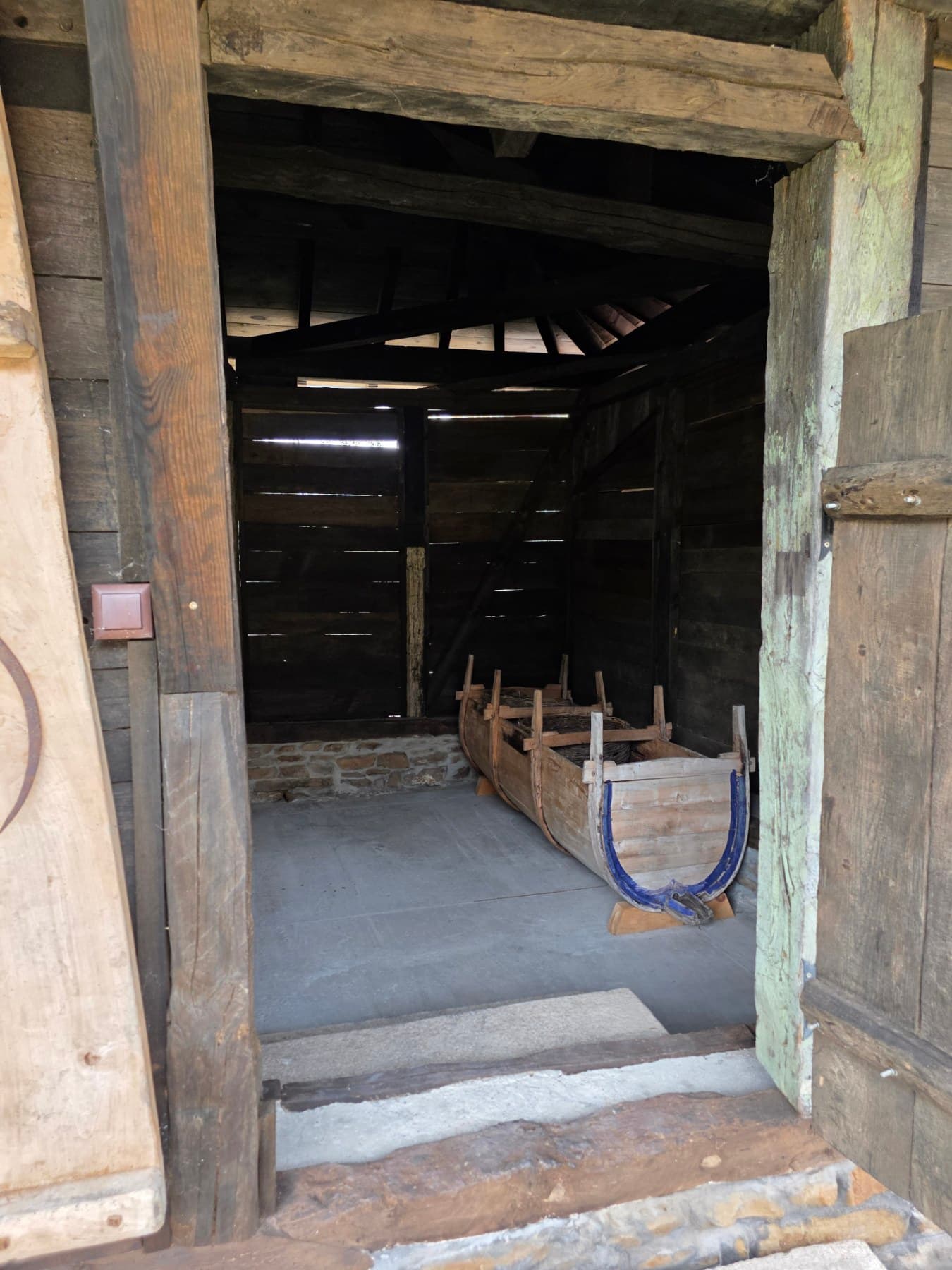 A wooden sled inside a farm outbuilding