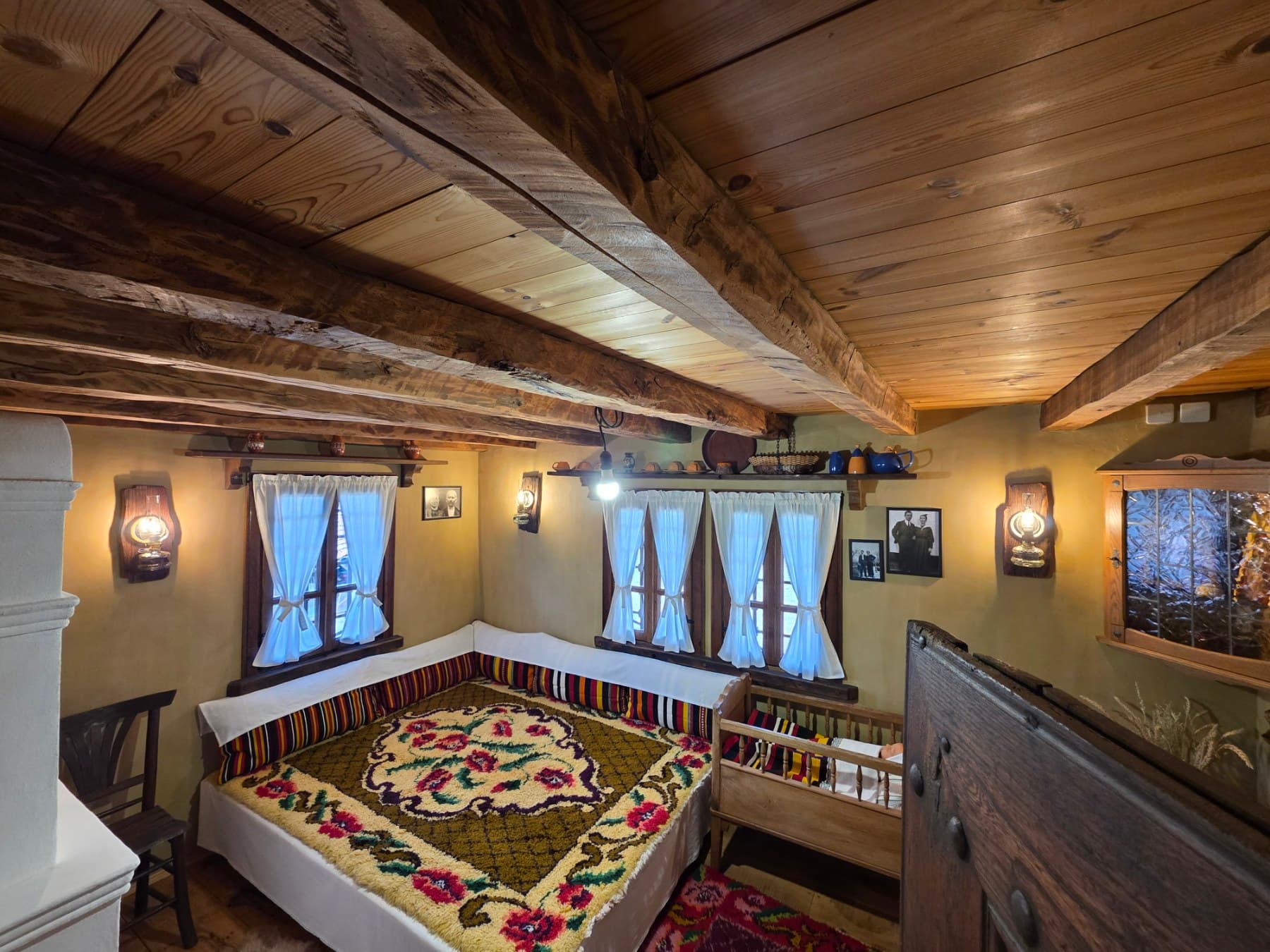A traditionally covered bed and wooden cradle
