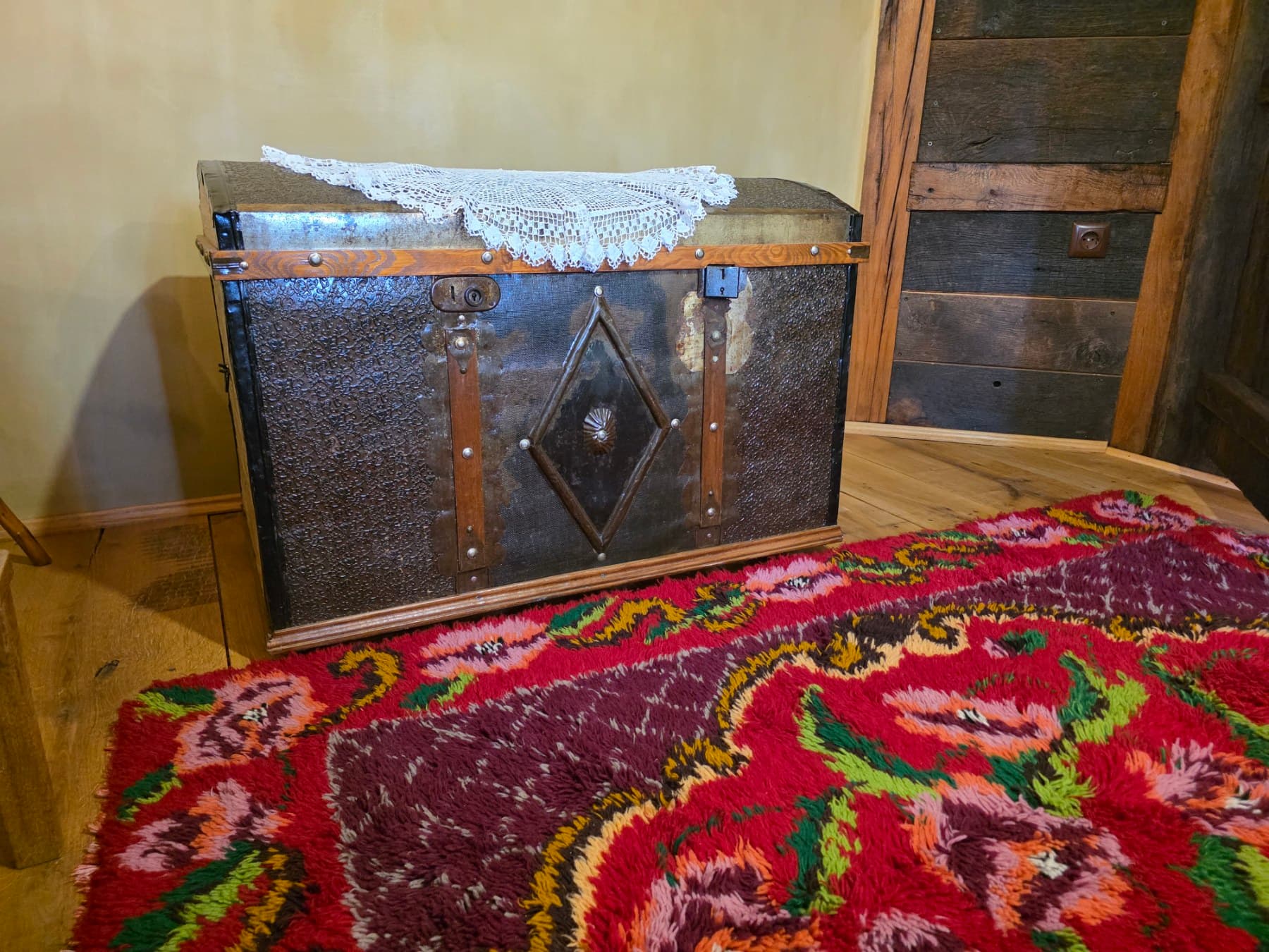 An antique chest beside a colourful rug
