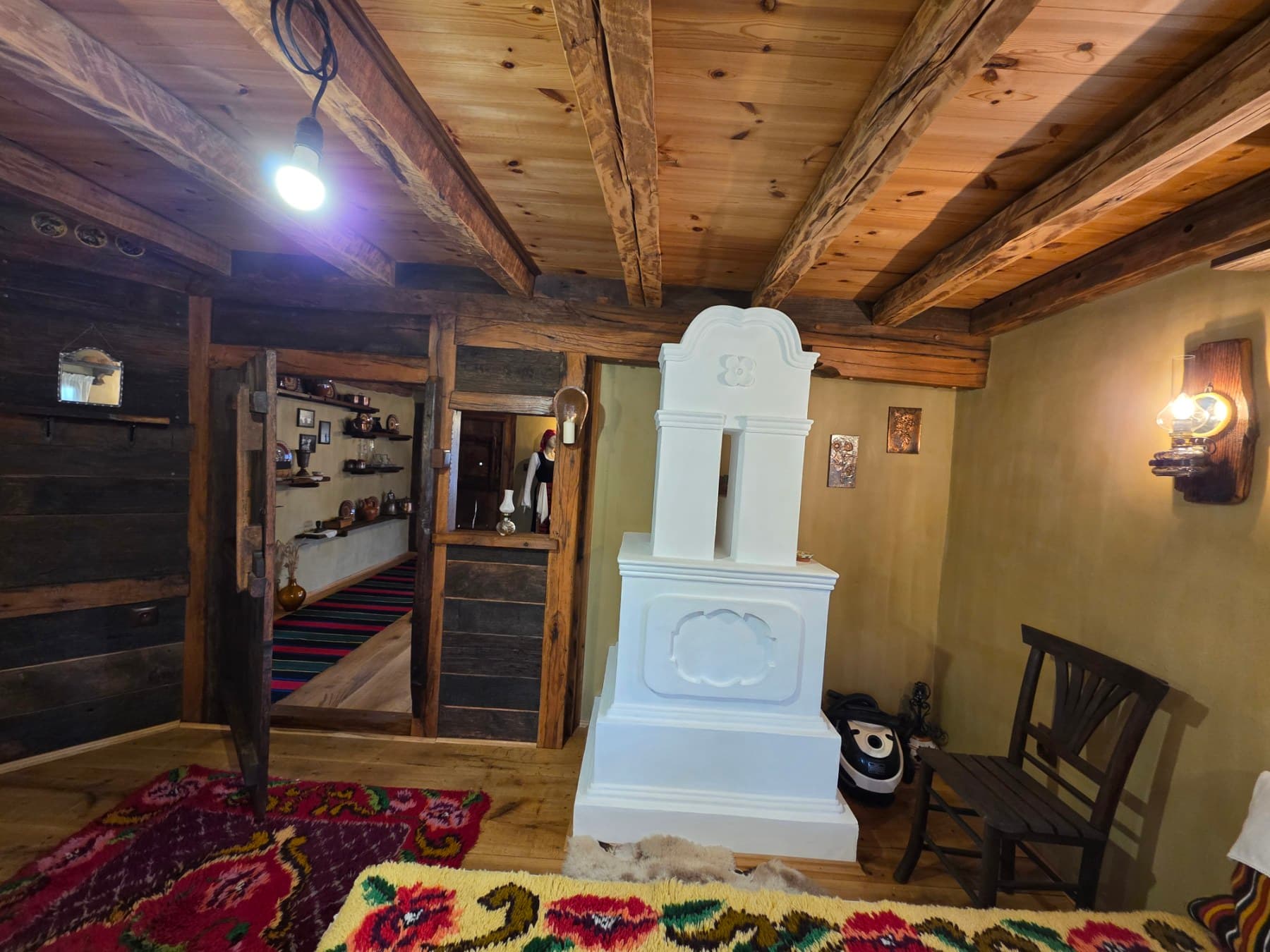 A white stove in a timber-beamed room