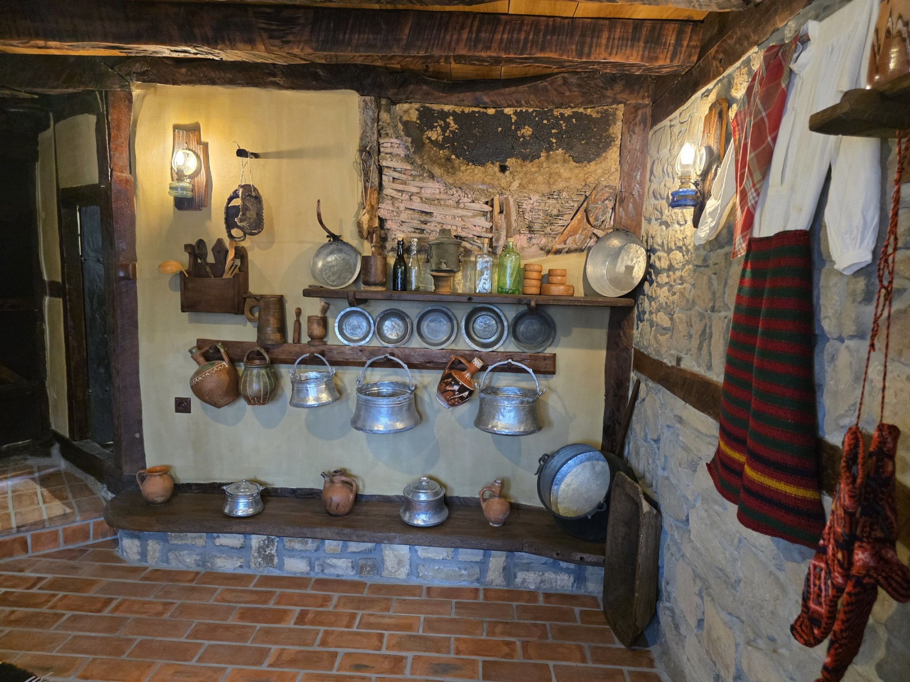Clay and metal utensils displayed in the old kitchen