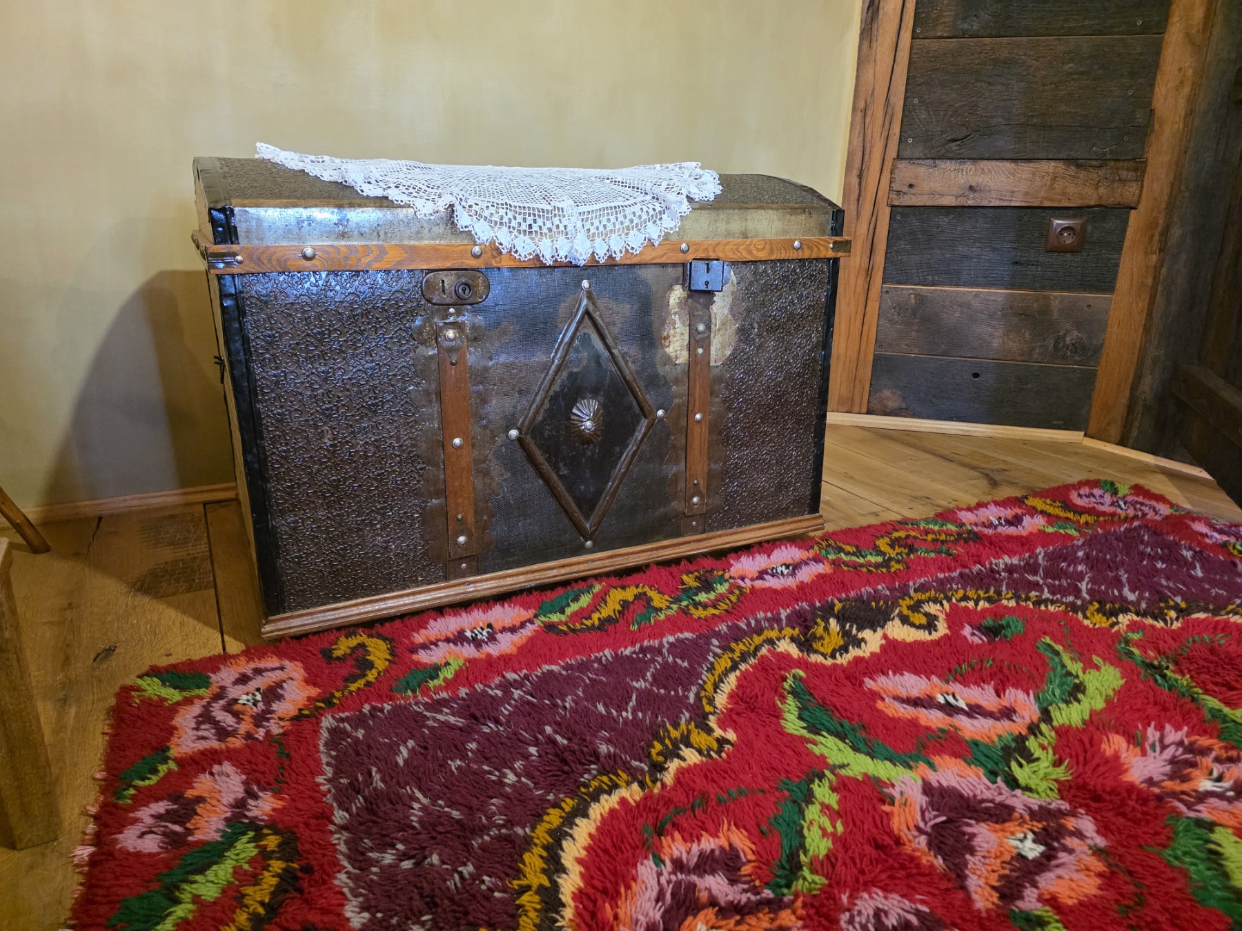 An antique chest beside a colourful rug
